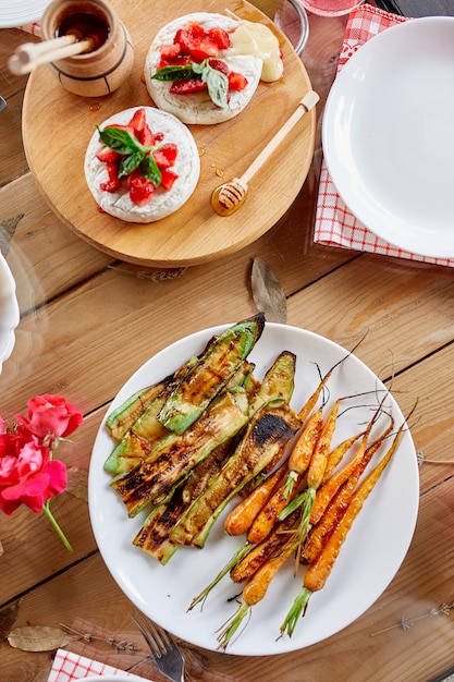 Calabacín a la plancha y zanahorias en un plato blanco