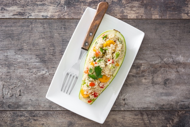 Calabacín relleno con quinua y verduras en la vista superior de madera