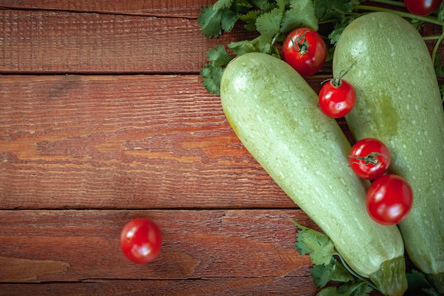 Calabacines y tomates sobre fondo de madera