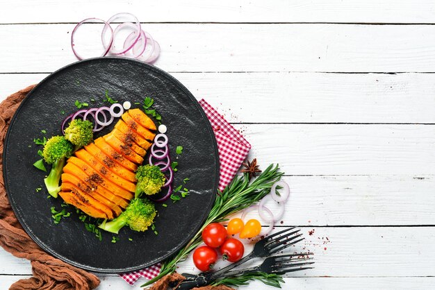 Calabaza al horno con verduras en un plato negro Vista superior Espacio de copia libre