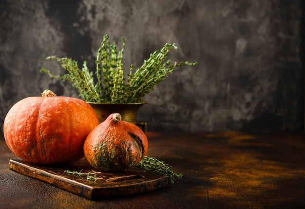 Calabaza, albahaca y tomillo sobre una mesa oxidada