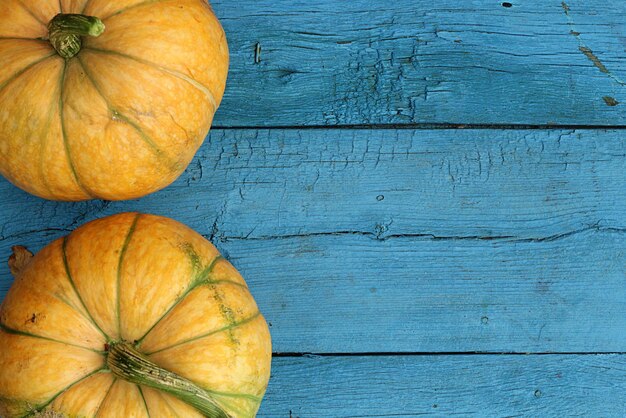 Foto calabaza amarilla sobre fondo de mesa de madera azul