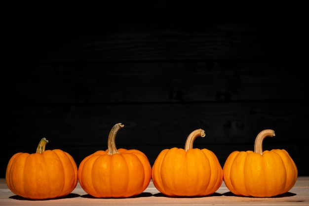 Foto calabaza amarilla sobre madera negra.