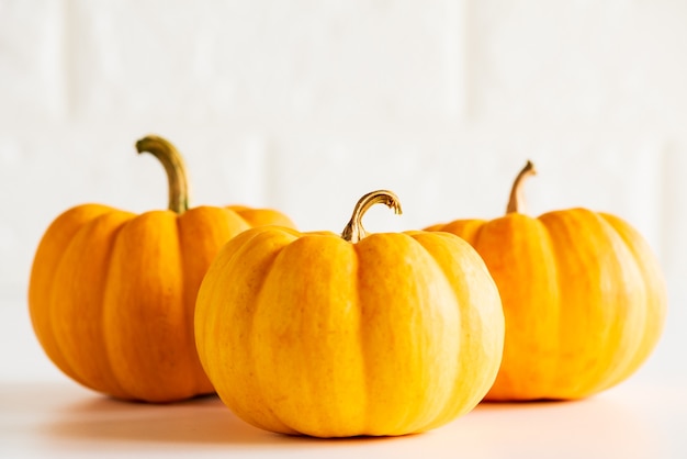 Calabaza amarilla tres en el fondo blanco del bloque de ladrillo. concepto de halloween.