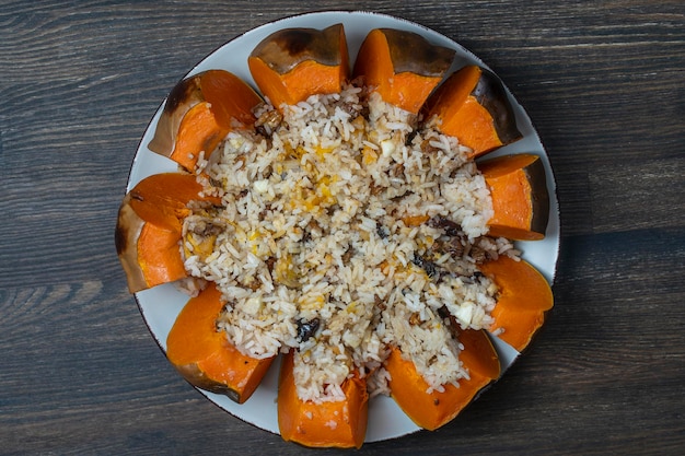 Calabaza asada rellena entera al horno rellena de una mezcla de arroz con pasas y especias