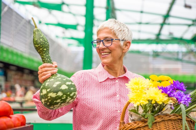 Calabaza de compra de la mujer mayor en mercado