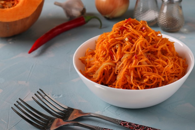 Calabaza coreana en un recipiente blanco sobre un fondo azul claro, Primer plano