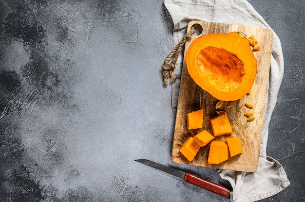 Calabaza cruda fresca en una tabla de cortar, cortada en cubos.