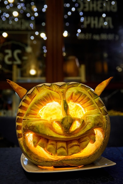 Calabaza decorativa naranja con cara tallada para Halloween