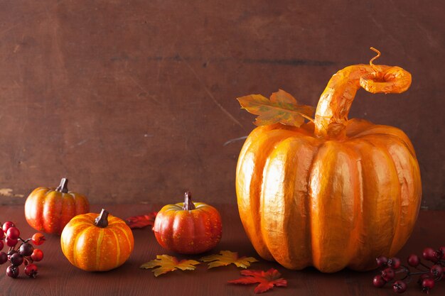 Calabaza dorada de papel maché decorativa y hojas de otoño para el día de acción de gracias de halloween