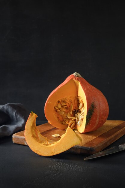 Calabaza grande orgánica sobre un fondo negro con decoraciones de halloween cosecha de otoño para fest