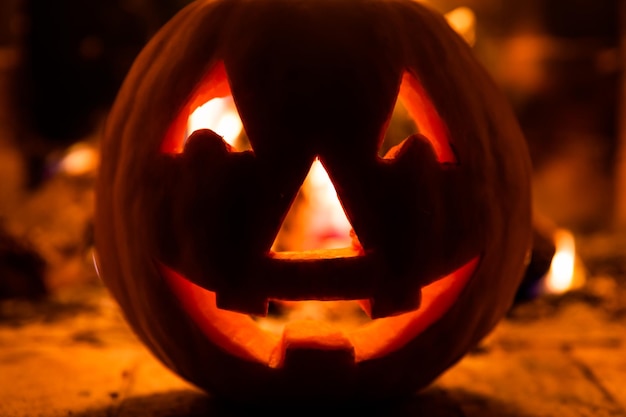 Calabaza de Halloween con cara de miedo sobre fondo de fuego