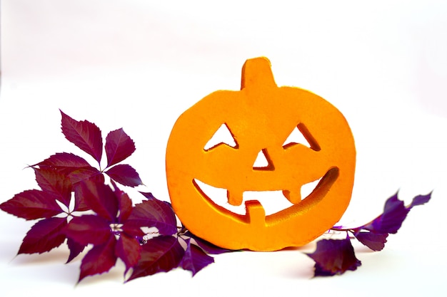 Calabaza de Halloween con hojas de otoño y blanco