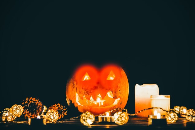 Calabaza de Halloween en la oscuridad. Enciende lámparas y velas. Vacaciones de otoño místicas. Detalles festivos. Tradición de truco o trato. Todos los Santos en octubre.