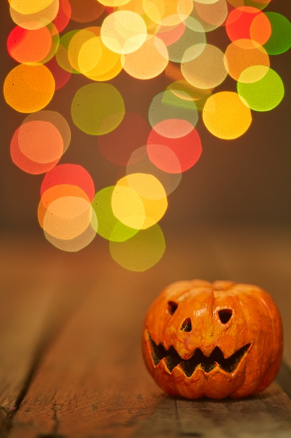 Foto calabaza de halloween sobre un fondo de luces bokeh