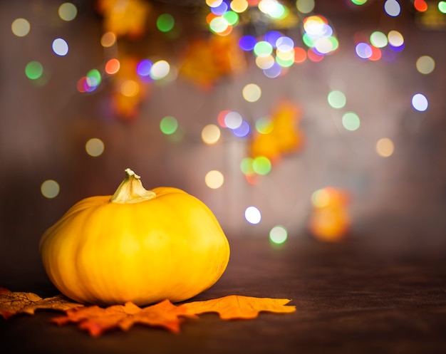 Calabaza en hojas de otoño. Fondo bokeh con espacio de copia, fondo de diseño colorido Halloween y otoño, espacio para texto