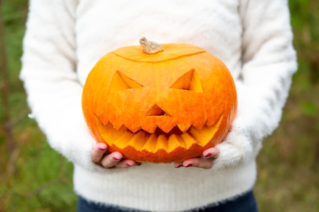 Calabaza jackolantern en manos de una chica closeup fiesta de Halloween