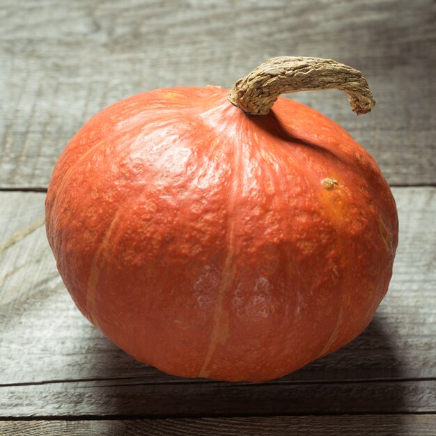 Calabaza madura naranja en tablero de madera. De cerca. Cosecha.