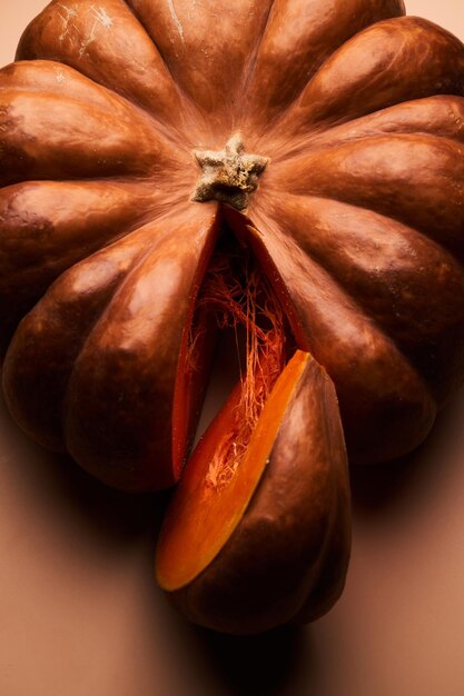 Calabaza madura en rodajas cerca de fondo naranja