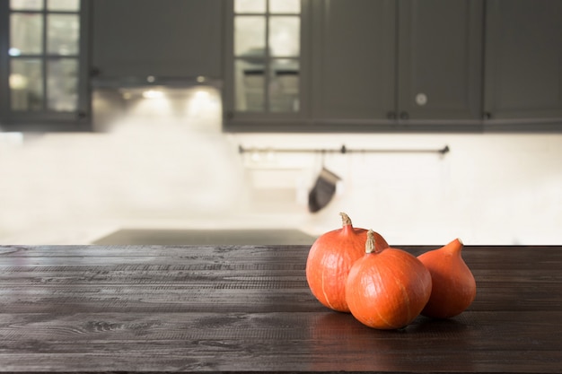 Calabaza madura sobre mesa de madera en la cocina moderna.