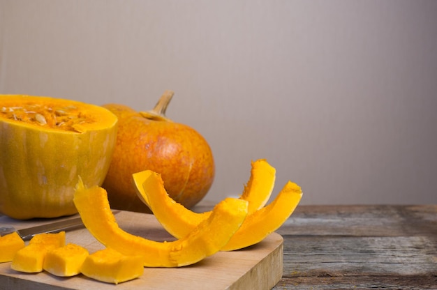 Calabaza madura y sus rodajas sobre una tabla para cortar