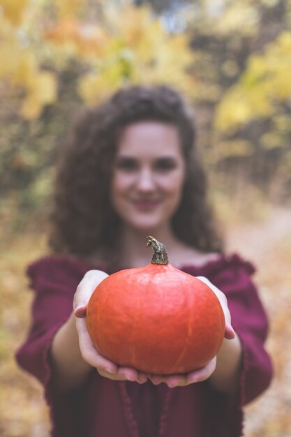 Calabaza en manos de una hermosa joven bokeh