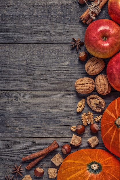 Calabaza y manzanas con nueces en una mesa de madera