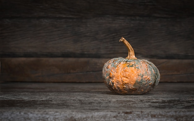 Calabaza en mesa de madera oscura.