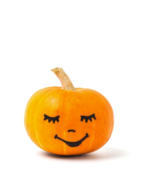 Una calabaza naranja madura con una cara pintada aislada en un fondo blanco