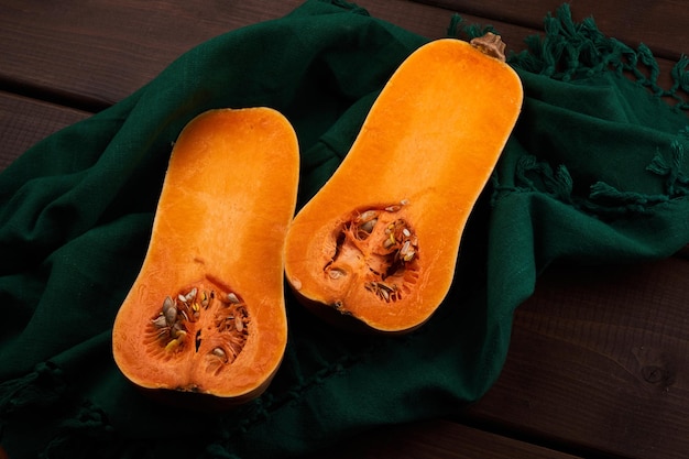 Calabaza naranja madura en rodajas cerca de fondo de madera