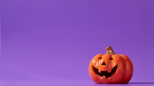 Calabaza naranja sobre violeta pastel