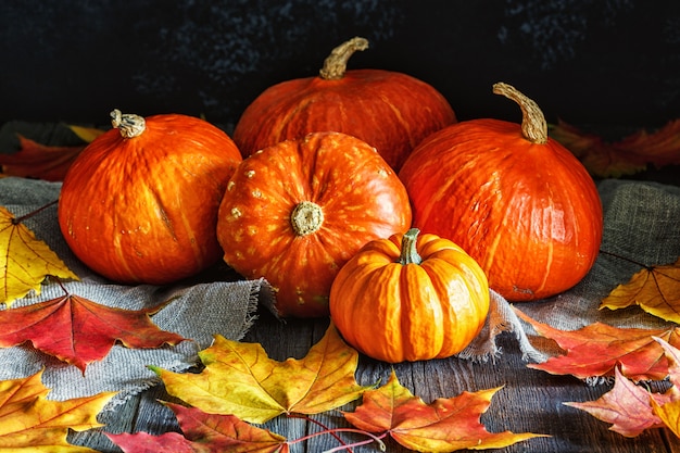 Calabaza de otoño con hojas de arce en madera.