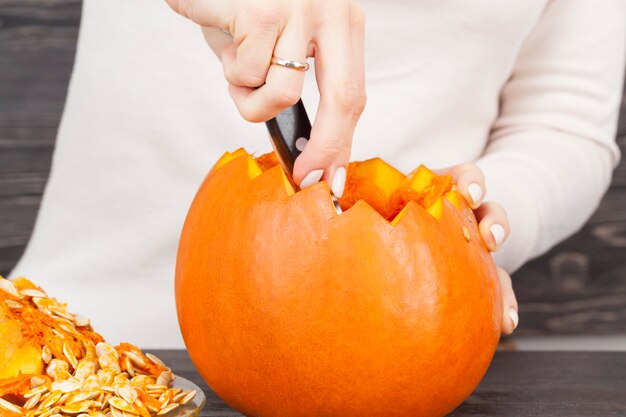 Una calabaza pequeña cortada con muescas afiladas, vista desde el interior de las semillas grandes