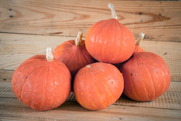 calabaza pequeña naranja en el fondo de la tabla de madera