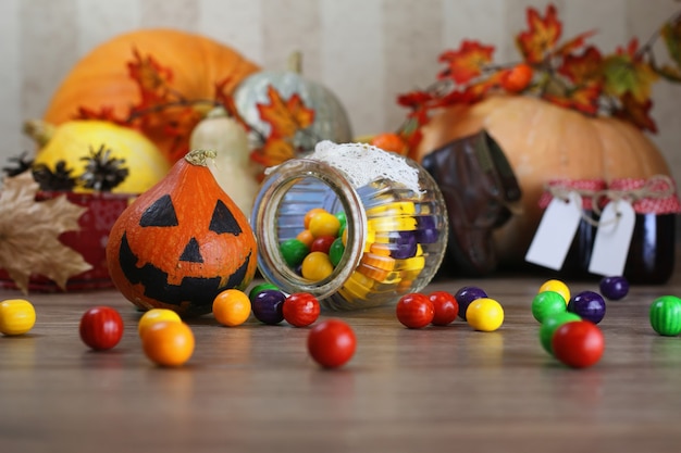 Calabaza en el piso con linterna de vela y dulces.