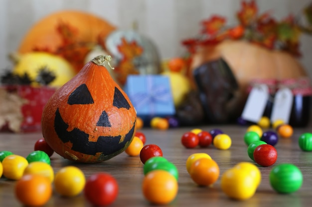 Calabaza en el piso con linterna de vela y dulces.