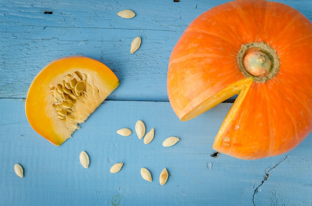 Calabaza y semillas de calabaza en superficie de madera