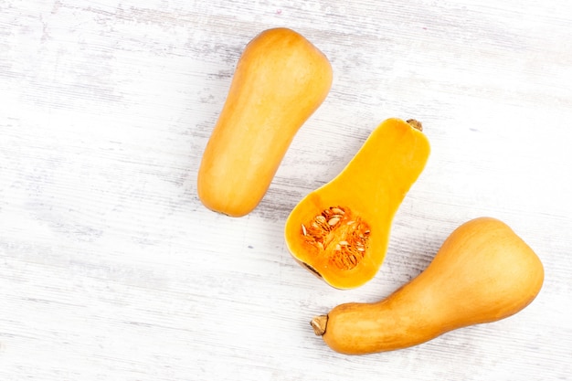 Calabaza sobre una mesa blanca. Dulce en forma de pera tres calabaza naranja