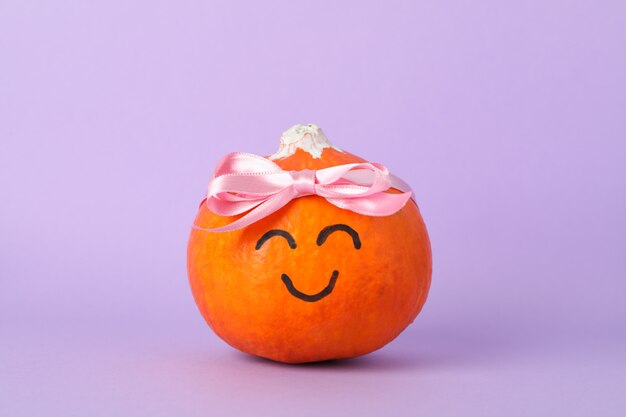 Calabaza con sonrisa y lazo en violeta, espacio para texto