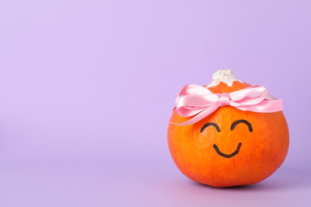 Calabaza con sonrisa y lazo en violeta, espacio para texto