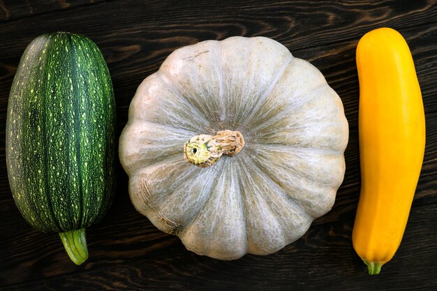 Calabaza y tuétano vegetal en la mesa de madera oscura plana