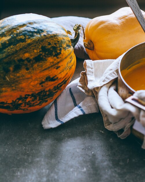 Calabazas brillantes, una olla de sopa de calabaza, platos de otoño.