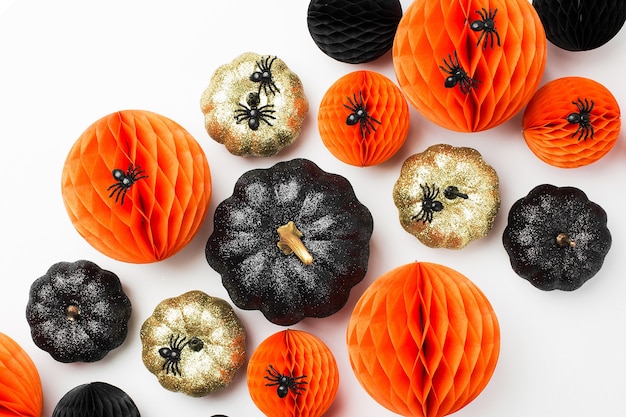 Calabazas decorativas brillantes y bolas de nido de abeja. Decoraciones de Halloween. Concepto de vacaciones de moda endecha plana, vista superior.