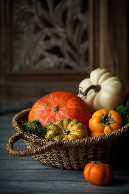 Calabazas decorativas en canasta sobre mesa de madera