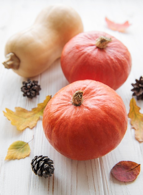 Calabazas decorativas de otoño con hojas de otoño sobre fondo de madera