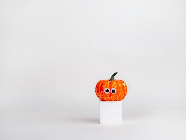 Calabazas divertidas con ojos en un cubo blanco Concepto de Halloween Idea creativa