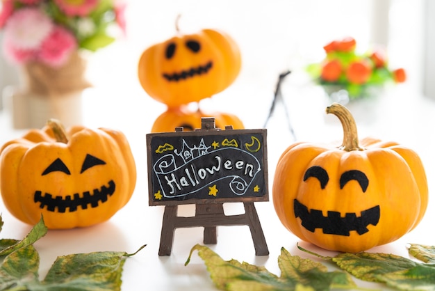 Foto calabazas fantasmas blancas y amarillas con sombrero de bruja y texto de feliz halloween