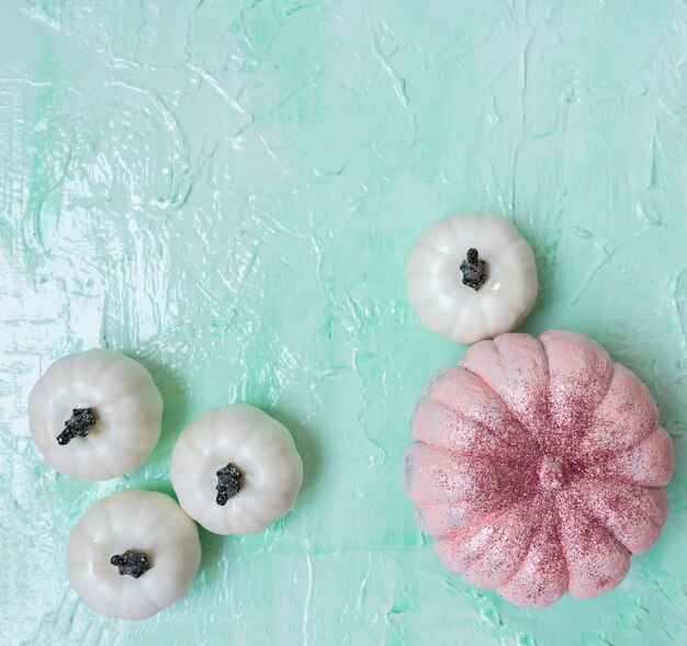 Calabazas de Halloween brillo rosa y blanco sobre fondo de menta