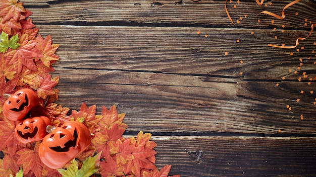 Foto calabazas de halloween con hojas de otoño sobre madera