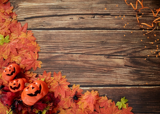 Foto calabazas de halloween con hojas de otoño sobre madera